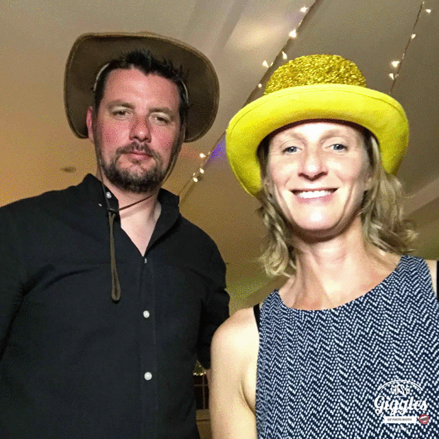 A couple posing for a FREE wedding photobooth photo in a yellow hat.