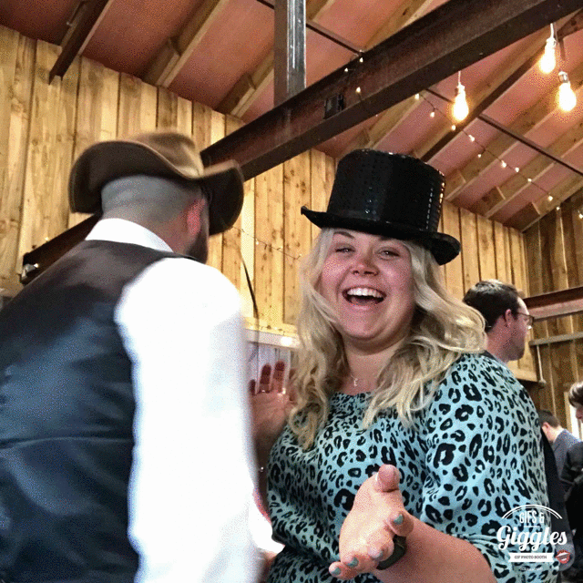A woman and a man, both donning cowboy hats, at a wedding ceremony.