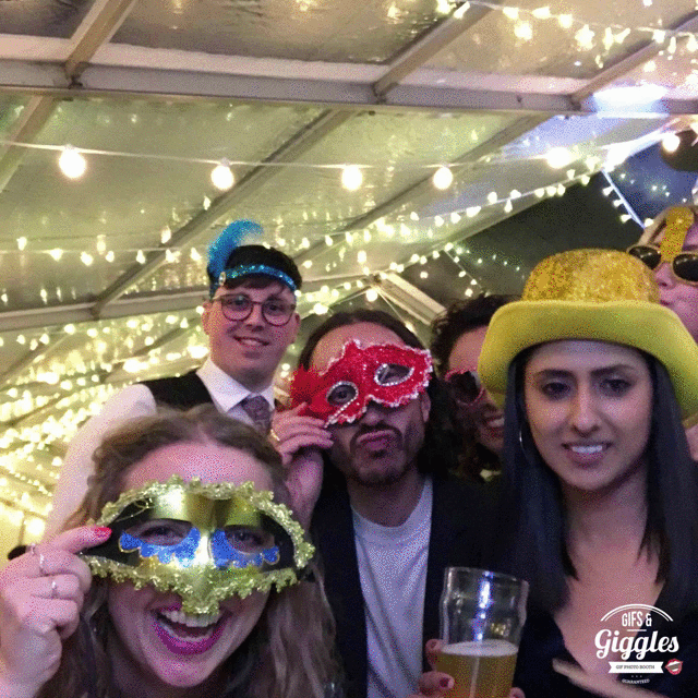 A FREE photobooth at a party captures a group of people wearing masks.