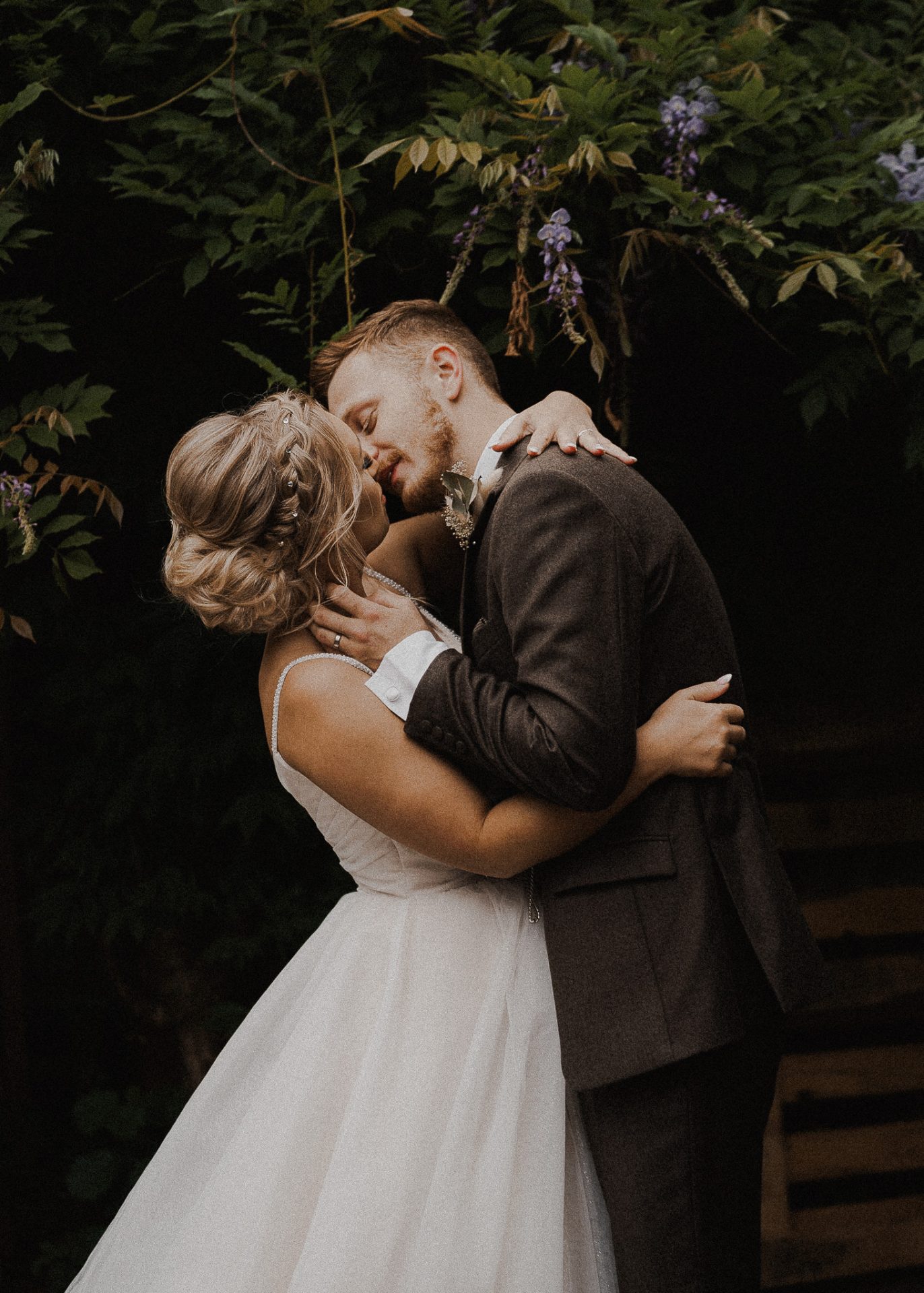 Wedding Photographs: Newlyweds kissing by a tree.