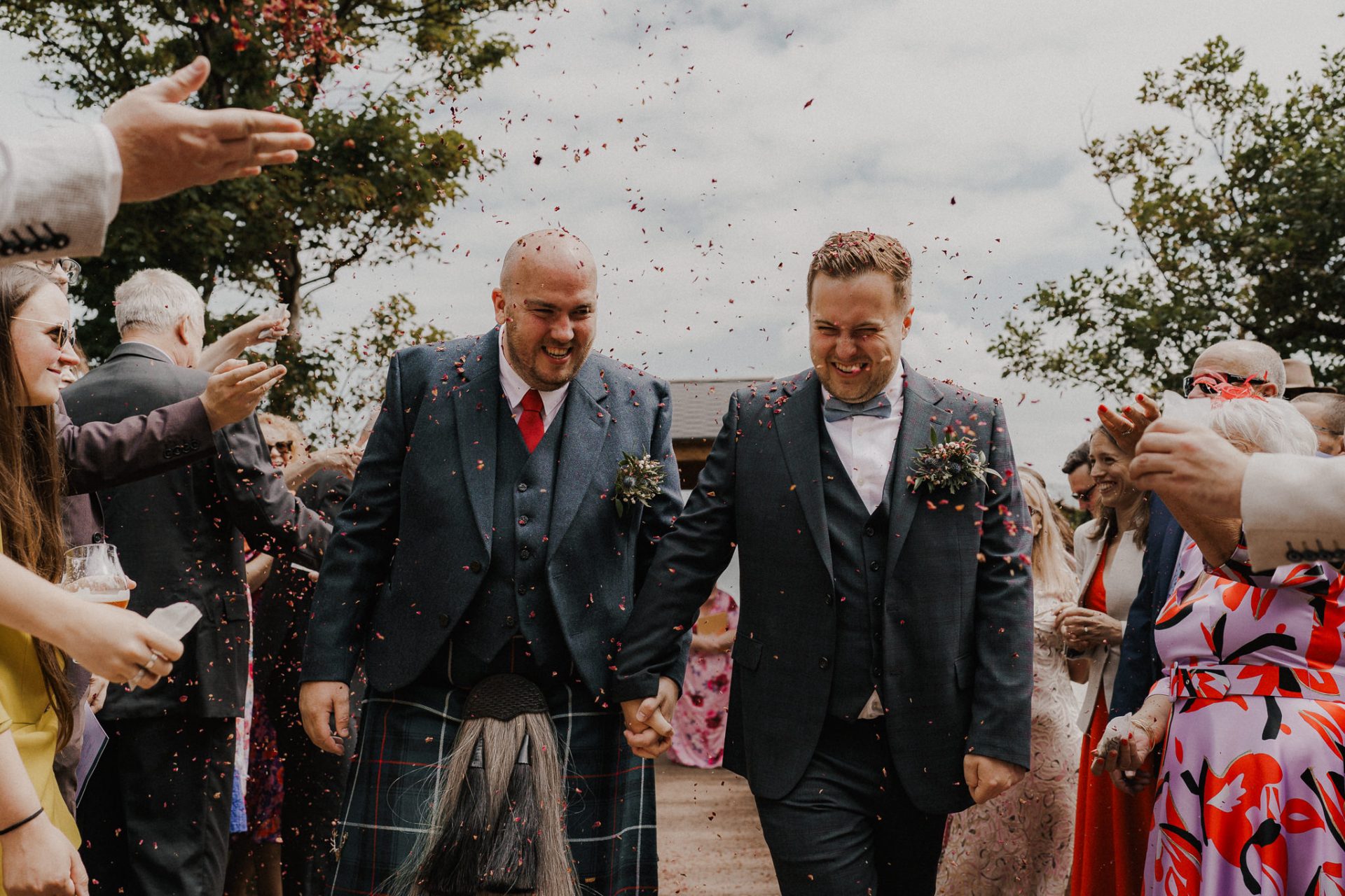 Wedding photographs capturing two happy grooms walking down the aisle amidst confetti.