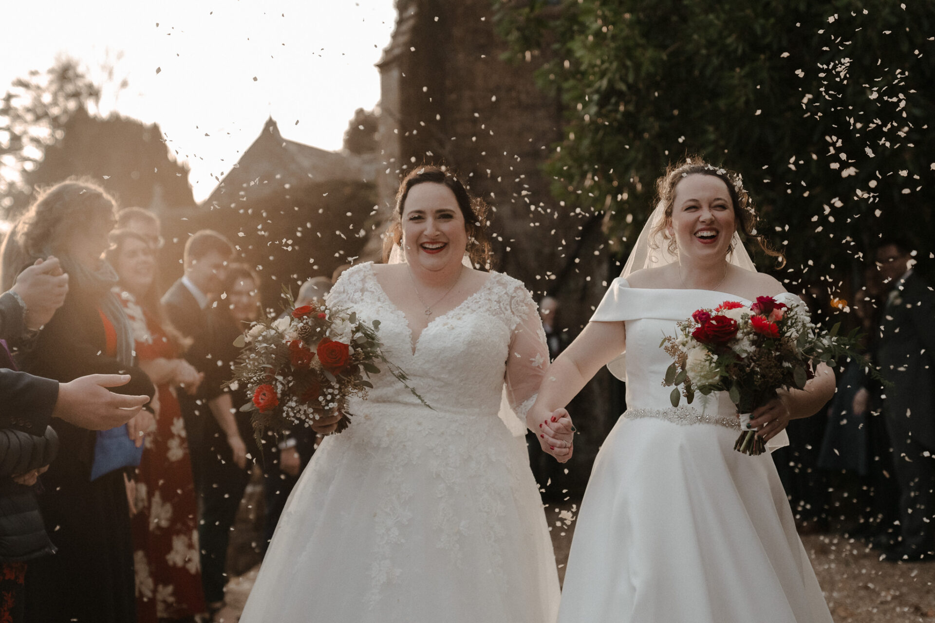 In recent weddings, two brides gracefully walk down the aisle while being showered in confetti.